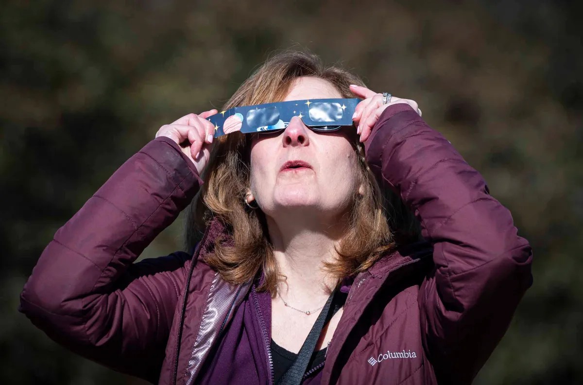 Woman using protective eyewear to view a solar event.