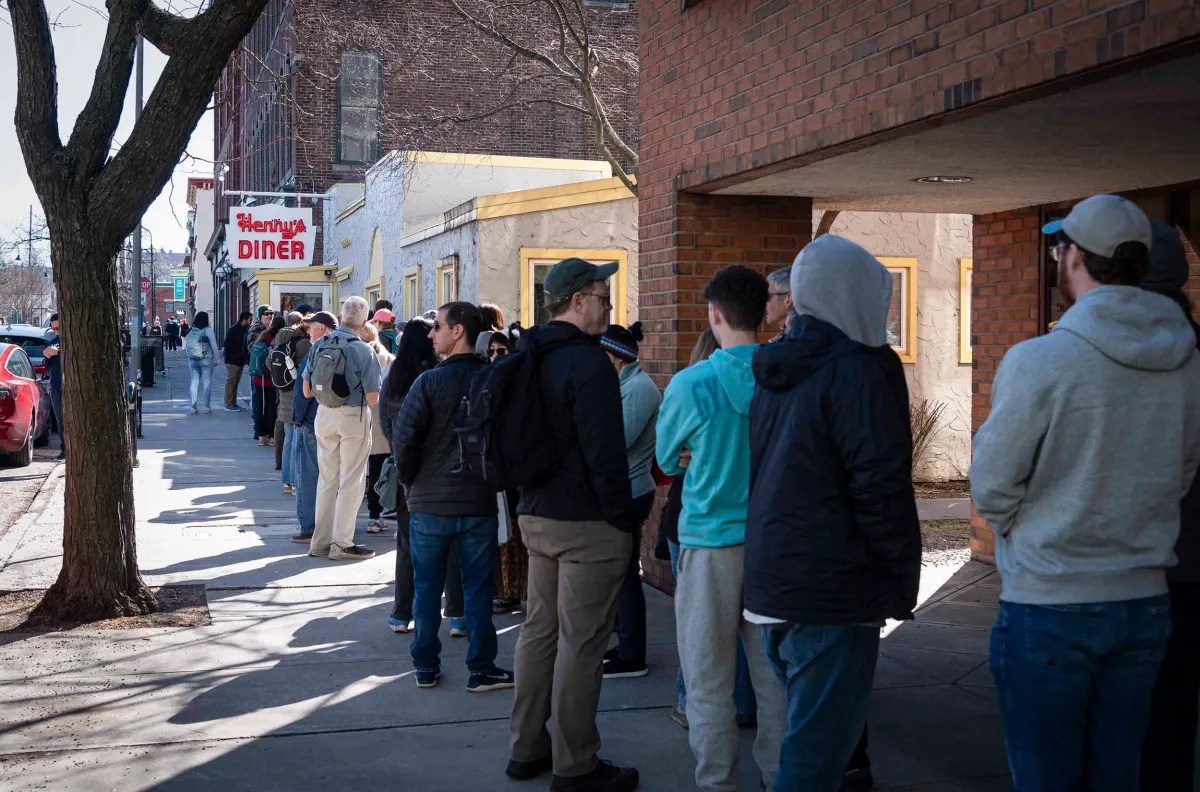Line of people waiting outside a diner.