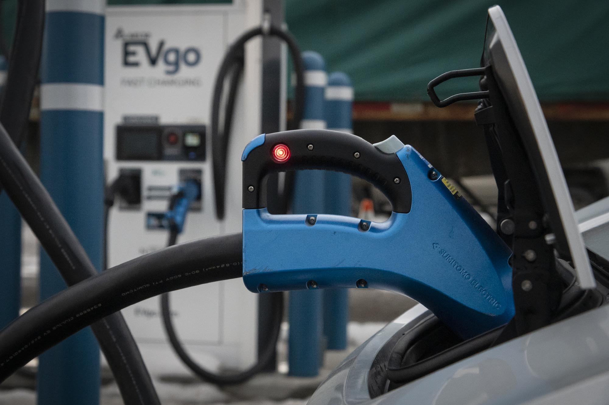 A blue electric car charger at a charging station.