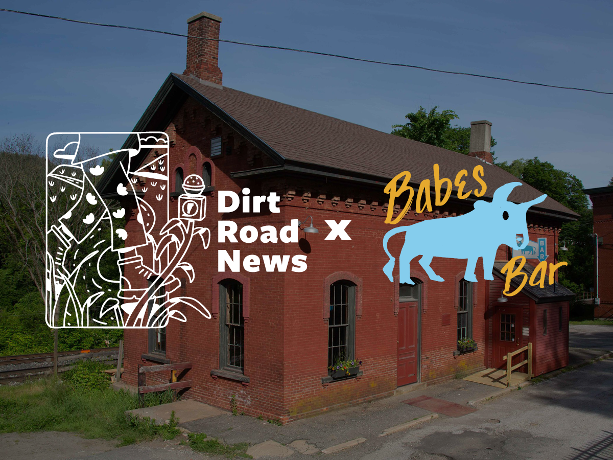 A red brick building with a chimney and two entrances features graphic logos for "Dirt Road News" and "Babes Bar" overlaid on the image.